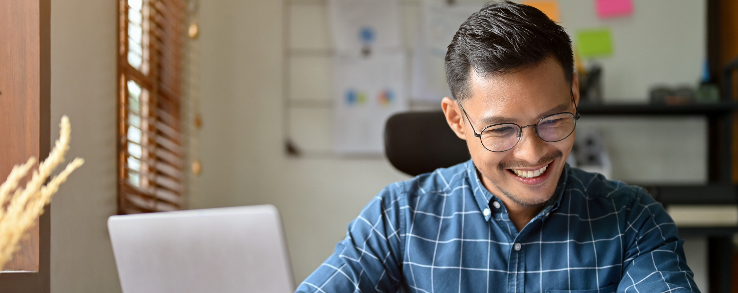 Smiling business owner working at their office desk.